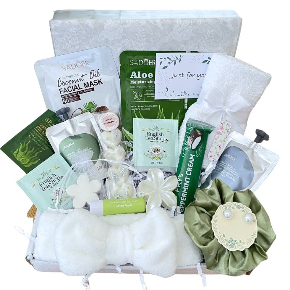 Sister Birthday self care present. A curated spa gift basket filled with skincare and self-care items, including SADoO facial masks, a green silk scrunchie, pearl earrings, a white hairand, a white face towel, Pearly Hair Clip, Frys Chcolate, Sleepy tea, seaweed eye soothers, lemon lavender wax melts, shampo and body was pouch, Mini nail file, arranged in a white box with pretty tissue and gift card of your choice