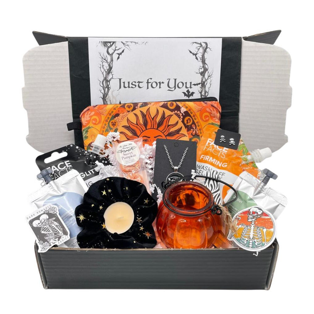 Gothic Gift box containing a good selection of items, glass pumpkin lantern, velvet star scrunchie, triple moon necklace, skull earrings, wax melts, scented tealight, shampoo, body wash, make up bag, Glitter gel mask, orange gel peel off mask, stickers, paked in to a black gift box.