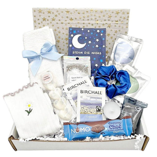Gift box with various items including eye masks, VEGAN chocolate, face towel, socks, wax melts, scented candle, soap, body wash, shampoo, bath salts with lavender, and hair scrunchie, packed in to a box with tissue and card of your choice.