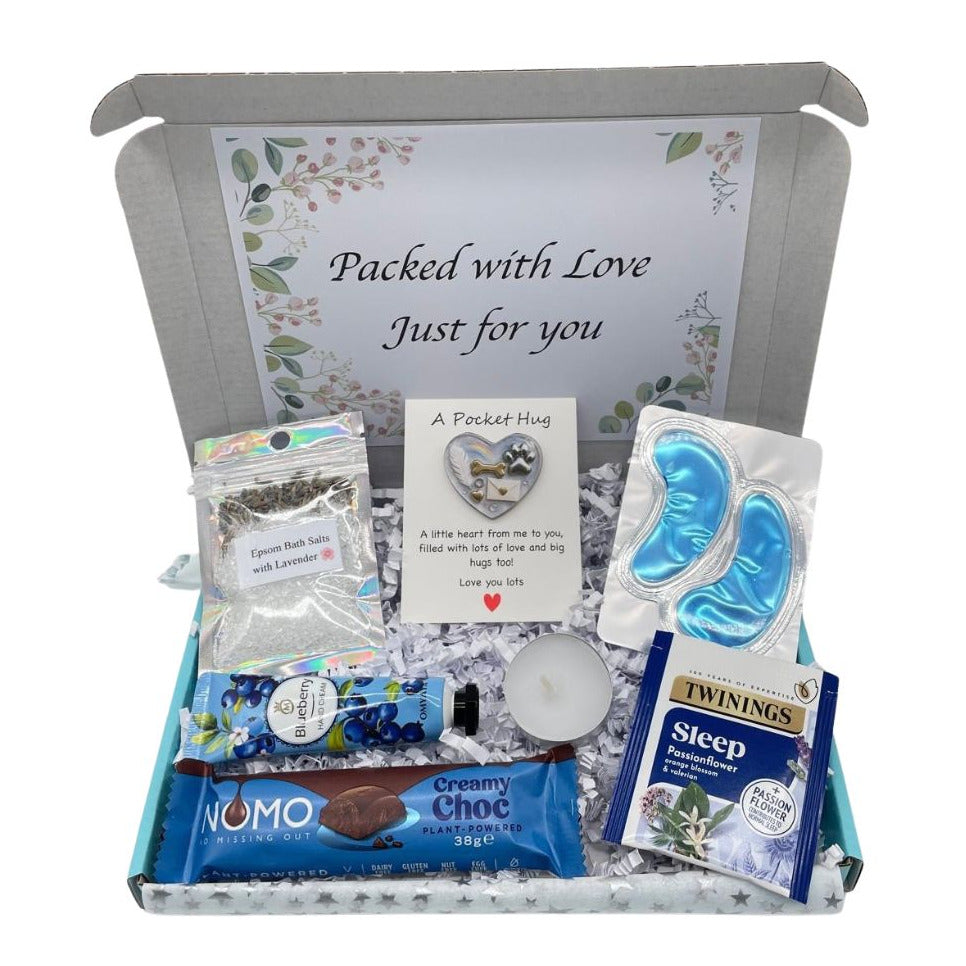 Gift box labeled 'Packed with Love Just for You' containing various items including a packet of Twinings tea, Nomo chocolate, and other small products.