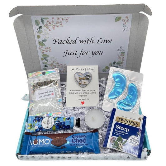 Pet Bereavement Gift box labeled 'Packed with Love Just for You' containing various items including a packet of Twinings tea, Nomo chocolate, and other small products.